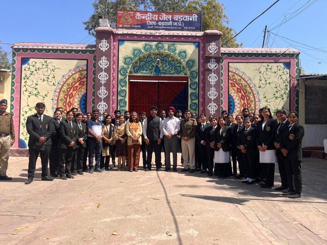 Students and staff photographed outside a decorated gateway during a college visit