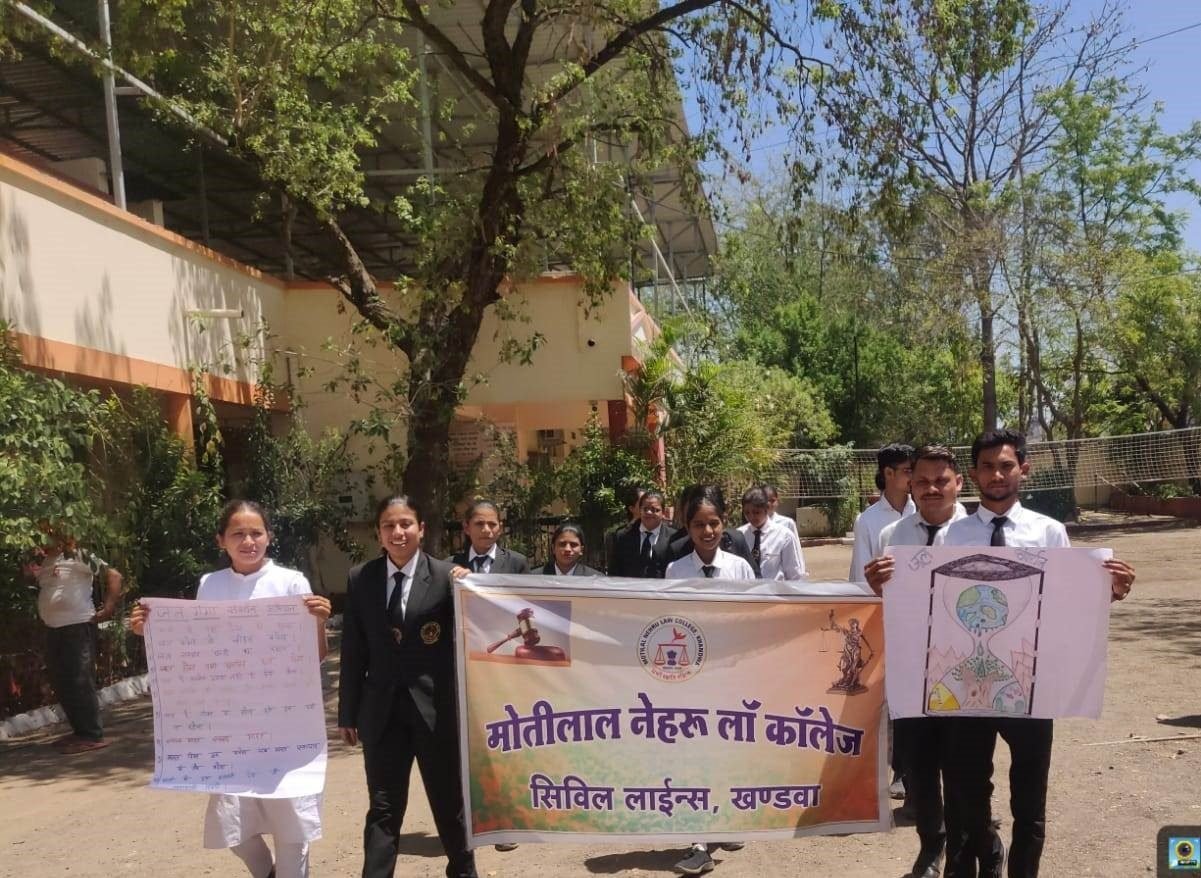 Students in formal attire holding a Motilal Nehru Law College banner during a campus outreach program